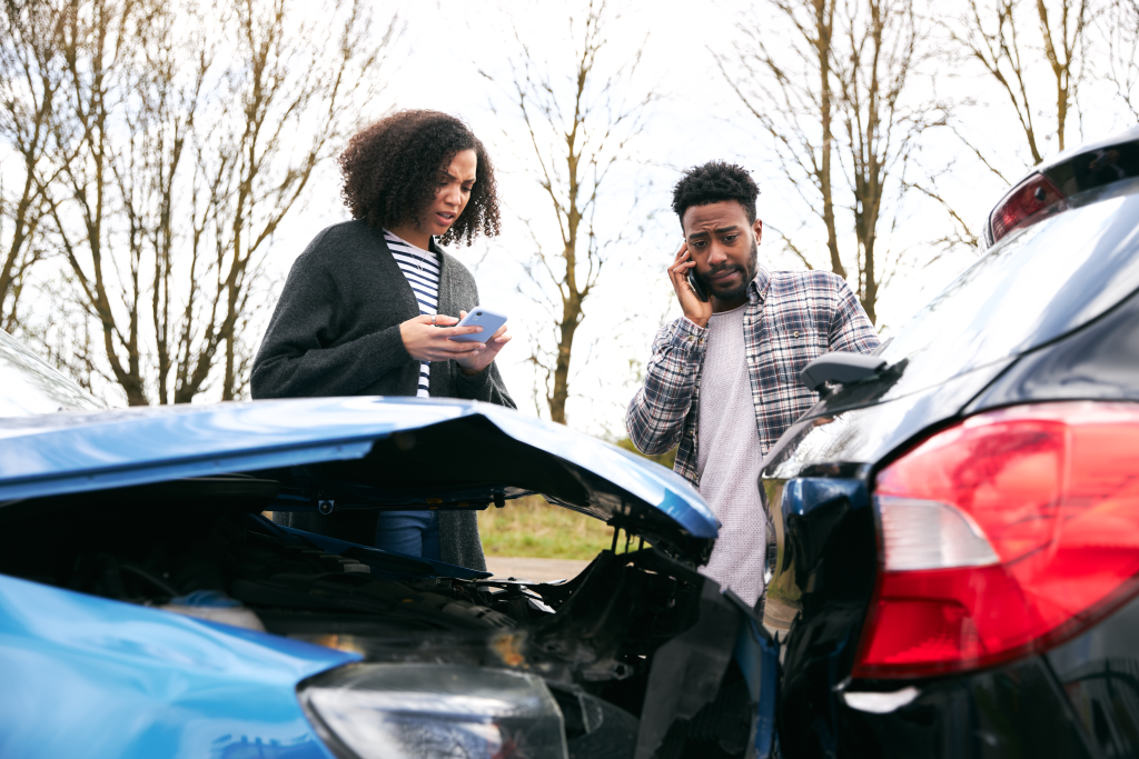 Couple exchanging car insurance details after road collision